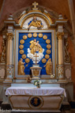 <center>Bozouls</center>Église Sainte-Fauste. Retable du Rosaire. 17e siècle. A gauche, de bas en haut, les 5 mystères joyeux  : L’annonciation ; La visitation ; La nativité ; La présentation de Jésus au temple ;   Le recouvrement de Jésus au temple Puis, les  mystères douloureux : L’agonie de Jésus au jardin des oliviers ; La flagellation ; Le couronnement d’épines ; Le portement de la croix ; Le crucifiement et la mort de Jésus Les 5  mystères glorieux : La résurrection ; L’Ascension ; La Pentecôte ; L’Assomption de Marie ; Le couronnement de Marie au Ciel. Les 5 mystères lumineux ne sont pas représentés car ils ont été institués en 1956 par Jean Paul II..