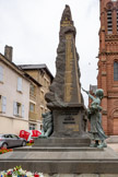 <center>Espalion</center>Église paroissiale Saint-Jean-Baptiste. Le monument aux morts, sur sa stèle en granit de Bretagne, porte gravés les 140 noms des morts de la guerre de 1914-1918 et les 18 de la seconde guerre mondiale. Sculpteur : E. Arsal, 1922.