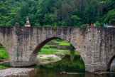 <center>Estaing</center>Le pont d'Estaing. Sa pile centrale est surmontée de deux éléments architecturaux se faisant face : une croix à l'amont et la statue de François d'Estaing à l'aval.