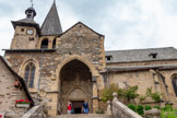 <center>Estaing</center>L'église Saint-Fleuret. Sur le parvis, à gauche,  se trouve une croix calcaire quadrilobée du XVIème siècle à double face. Sur une face elle représente en bas-relief le Christ en croix au-dessus d’une mise en tombeau, en deuxième face une pieta entourée de deux petits anges.