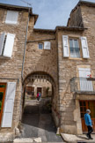 <center>Sévérac-le-Château</center>Porte Latazou. Située en contrebas, à gauche de la place de l’église, elle jouxte l’emplacement de l’hospice qui dépendait du couvent, attesté dès le XIIIème siècle. Latazou : de l’occitan latager, battre le grain à coups de lattes. Nom de l’aire où l’on battait les céréales prélevées pour la dîme.