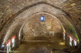 <center>Saint-Jean-Pied-de-Port</center>Un escalier exigu permet d'accéder à une vaste salle souterraine médiévale voûtée en ogive dont la fonction d'entrepôt de marchandises paraîtrait plausible. Le mur du fond de la salle voûtée médiévale est percé par une grande porte en plein cintre et deux fenêtres, assurant la ventilation de cette pièce. Murées pour une raison inconnue, des pierres d'encadrement délimitent ces ouvertures.