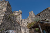 <center>Château des Moines.</center>A droite, la partie du XIIe siècle de la maison de la sorcière. En contrebas de la chapelle, des hommes attachés au service temporel de l’Abbaye, vraisemblablement des officiers ou des soldats, vont se faire édifier des maisons conçues comme des bastions.
Six maisons datent de cette période, une septième se situe nettement en dehors des fortifications au Nord. Elles sont caractérisées par un bel appareillage (malheureusement souvent à l’état de vestiges). A l’origine, ces maisons présentaient un décor plus travaillé, notamment des fenêtres géminées dont une colonnette soutenait un chapiteau.