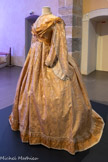 <center>Chapelle de l’Observance.</center>ROBE DE BAL A GRANDE CRINOLINE PLONGEANTE FRANCE PÉRIODE SECOND EMPIRE CIRCA 1865 Taffetas de soie damassé moiré jaune paille à manches en pagode. Parement en falbalas de soie crantée à niché de perles nacrées.