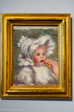 <center></center>Auguste Renoir
Limoges, 1841 - Cagnes-sur-Mer, 1919
L'Enfant au biscuit, vers 1898
Huile sur toile
Jean, second fils d'Auguste Renoir né en 1894, est saisi sur le vif, empoignant de ses doigts boudinés un biscuit qu'il dirige vers sa bouche. Il fait la moue et son regard plongé dans le vague ne regarde ni l'objet de sa gourmandise, ni le peintre qui lui est pourtant familier, ni le spectateur. Il est calme, comme amolli par la volumineuse charlotte à rubans (ou béguin) et le corsage gonflé qui l'enveloppent et qui, de toute manière, se prêteraient mal aux jeux de l'enfance. L'œuvre est probablement une étude préparatoire à la lithographie L'Enfant au biscuit de 1898.