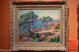 <center></center>Le Dramont à travers les pins
Clémentine Ballot (1879, Paris - 1964, Paris)
1913, huile sur toile, 60x73cm Collection particulière.
Clémentine Ballot saisit le Dramont depuis la Baumette, située peu après le château d’Agay, de l’autre côté de la baie. Elle compte parmi les rares femmes artistes, aux côtés d’Anna Boch (1848-1936), à avoir peint l’Estérel.
Parcourant la France, elle séjourne également dans la vallée de la Creuse où elle rencontre de nombreux artistes ayant eux aussi travaillé dans le massif, tels que Léon Detroy, Eugène Alluaud, Paul Madeline et surtout Armand Guillaumin, avec qui elle noue une solide amitié dès 1912. C’est sur ses conseils qu’elle découvre Agay en 1913: ensemble, ils peignent régulièrement sur le motif et fréquentent les mêmes sites. Aujourd’hui méconnu, l’œuvre de Ballot est pourtant salué et récompensé de son vivant et mérite d'être redécouvert.