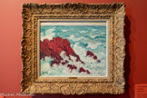 <center></center>Les roches rouges
Georges d’Espagnat (1870, Melun -1950, Paris)
1901, huile sur panneau, 60 x 68 cm Versailles, musée Lambinet Inv. 91.9.18.
Dans Les Roches rouges d’Agay, les assauts de la mer submergent le minéral selon un jeu savant d’échos formels. Le tracé accidenté de la crête rocheuse se prolonge dans l’ondulation bleue des flots, tandis que l’écume blanche semble détacher quelques fragments de roche qui se mêlent à elle. Pour d’Espagnat, la roche est à la fois un langage formel et un laboratoire émotionnel.
Le cadrage resserré et la force décorative du paysage rappellent les estampes japonaises, qui ont profondément influencé les peintres occidentaux modernes. Le jaillissement des trois vagues en forme de crochet évoque celles des maîtres japonais Utagawa Hiroshige et Katsushika Hokusai