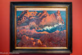 <center></center>L’île Besse à Agay
Armand Guillaumin (1841, Paris -1927, Orly)
Huile sur toile, 73 x 92 cm Collection particulière.
Le motif de la roche constitue un fil conducteur de l’œuvre d’Armand Guillaumin, qu’il explore à l’huile, au pastel mais aussi par la lithographie. Ses séjours répétés dans l’Estérel favorisent l’émergence d’un style personnel, de plus en plus graphique et vif, qui dépasse le mouvement impressionniste auquel le peintre est associé. Quel que soit le médium utilisé, Guillaumin construit la roche par une juxtaposition de petits traits et de zones hachurées qui modulent les surfaces. Le cadrage rapproché sur l’île Besse, la ligne d’horizon élevée, rythmée par les crêtes rouges, ainsi que la roche soulignée par l’écume blanche et les zones d’ombre, créent un ensemble d’une grande puissance décorative.