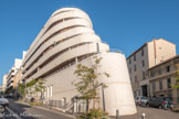 <center>Rue Malaval</center>L’effet de proue d’un navire est recréé par la forme triangulaire du bâtiment et renforcé par la pente : plus de 7 mètres de dénivelé entre le haut de la rue Malaval et le point le plus bas de l’îlot à la rencontre des rues Malaval et Fauchier. Cette architecture est bien évidemment en clin d’oeil à Marseille et à la mer. La forme du bâtiment avec une proue arrondie et des balcons filants rappelle sans équivoque un bateau de croisière.