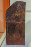 <center>Reflets du Nil</center>Plaque représentant le dieu Hâpy
Nouvel Empire, 18e dynastie (1550-1295 av. notre ère)
Bronze
GENÈVE, FONDATION GANDUR POUR L’ART. 
<br>Le dieu Hâpy est la divinisation de la crue du Nil qui répand le limon. Ce dieu, coiffé d’une botte de papyrus, est doté de seins nourriciers, d’un ventre rebondi et d’une peau bleue ou verte comme l’eau. Il est appelé chaque année à jaillir pour faire monter les eaux du Nil. Un hymne et de nombreuses offrandes sont jetées dans le flot afin qu’il se manifeste favorablement. En retour, il apporte sur une natte deux aiguières au moyen desquelles il déverse le flot sur la Haute et la Basse Égypte.