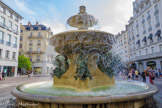 <center>La place Grenette.</center>La fontaine située au fond de la place non loin de l'ancien hôtel de ville, dénommée Château d'eau Lavalette, a été mise en service en 1827 après l'administration du marquis de Lavalette, alors maire sortant de Grenoble et créateur du premier réseau de canalisation des fontaines de la ville. Cette fontaine a été conçue par le sculpteur Victor Sappey et produite par le fondeur Crozatier. Le monument réalisé en pierre de Sassenage, est orné de quatre angelots chevauchant des dauphins en bronze, emblèmes du Dauphiné.