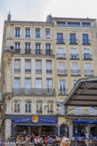 <center>La place aux Herbes.</center>Durant le Moyen Âge, elle accueillait le siège (banc) du conseil de la cité, pouvoir populaire mis en place à Grenoble selon charte communale de 1242-1244. C'est donc en ce lieu, symbolisé par un simple banc de pierre sur lequel les consuls venaient s'asseoir, que les Grenoblois venaient discuter publiquement et librement des affaires de la cité mais, c'est sur même lieu que se déroulèrent également, jusqu'au XVIIe siècle, les exécutions publiques. Cette petite halle date de la fin du XIXe siècle. Son vaste toit à quatre pans permet de protéger les étals de fruits, de légumes et de fleurs.