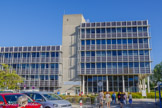 <center>Synchroton à rayons X de Grenoble.</center>Bâtiment administratif. L’ESRF est née d’une réelle volonté européenne de faire avancer la science des rayons X. En 1988, 11 nations européennes ont uni leurs forces pour construire la source de lumière synchrotron de « troisième génération » la plus performante au monde et la plus intense. Ce projet visionnaire a fortement contribué à l’excellence de la recherche européenne. Trente ans plus tard, l’ESRF est une référence mondiale, qui développe des technologies innovantes qui bénéficient aux synchrotrons nationaux. Aujourd’hui, le synchrotron européen de Grenoble continue de jouer un rôle pionnier et de repousser les limites de l’exploration scientifique de la matière, en construisant une nouvelle génération de synchrotron. Equipement de recherche fondamentale, ouvert à la recherche appliquée et industrielle, l'ESRF est la plus intense des sources de lumière synchrotron au monde. Elle doit son succès à sa gouvernance internationale avec 19 pays partenaires, dont 13 membres et 6 associés scientifiques.