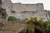 <center>Vogüé</center>Le château de Vogüé. Le donjon, tour carrée de 9 mètres de côté, s'élevait au-dessus de cet emplacement. Il dépassait certainement dans sa hauteur les murs actuels. Sa base était creusée dans le roc et formait une salle basse comportant trois côtés fermés par le rocher. Un quatrième mur d'une épaisseur de 1,75 m, donnant sur l’actuelle cour intérieure, fermait la salle. Cette ancienne partie du château a été probablement édifiée au XIIe siècle. Dans la première partie du XVIIe siècle, le château subit d'importants remaniements. Le donjon est alors englobé dans la construction de l'aile Est du château dont on peut voir les vestiges en arrière plan..
Au milieu XIXe siècle, menaçant ruine, le donjon est abattu. Aujourd'hui, seules la partie basse (ici) et une partie d'un mur du premier étage témoignent encore de sa présence.