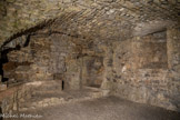 <center>Vogüé</center>Le château de Vogüé. L'aménagement de la cuisine remonte aux XIIIe ou XIVe siècle.
Accolée au donjon, elle était éclairée par une meurtrière percée dans le mur sud qui fut bouchée au XVIIe siècle lors de la construction des voûtes soutenant le jardin suspendu.
La cuisine était composée d'un puits qui donne sur une citerne creusée dans le roc alimentée par un réseau de canalisations récupérant les eaux de pluie. Sur le mur du fond, furent aménagés à gauche un four (dans l'angle) et à droite un espace pour la lessive (la bugade)