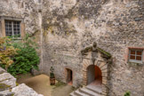 <center>Vogüé</center>Le château de Vogüé. Cour intérieure. La grande porte d'entrée à bossages ornée d'un fronton brisé triangulaire et la petite porte moulurée en anse de panier de la salle Rochemure, cette salle ayant été aménagée au xve siècle par les Rochemure.