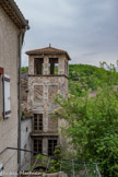 <center>Vogüé</center>Place de la Cadabielle
C’est le point d’arrivée d’un très ancien chemin (derrière vous) qui reliait la vallée du Rhône au PUY EN VELAY, très fréquenté par les muletiers qui montaient le vin de la vallée du Rhône jusqu’ aux plateaux du Velay et, redescendaient les céréales, en passant la rivière au gué de VOGÜÉ. La tour bâtie en pierre de VOGÜÉ, ressemblant à un clocher  est le haut de la cage d’escalier de la maison ROUSSEL, Intendant du Château au XVIIème siècle.