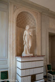 <center>Grande antichambre.</center>Statue : Hébé. Sculpture représentant une femme debout, drapée à l'antique, tenant de sa main droite une amphore et de la gauche une coupe. Elle est couronée de fleurs. Fille de Zeus et d'Héra, la déesse Hébé est l'échansonne des dieux. Ainsi elle est représentée tenant une amphore et une coupe.