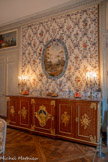 <center>La Salle à manger </center>Grand buffet à cinq vantaux avec placage de bois de violette, marbre Rance et bronze doré. Chaque méplat central est délimité par une moulure, et le centre des panneaux est occupé par deux chutes de trophées pour les côtés, représentant les attributs des Sciences et des Arts et, sur le vantail central, de la figure d'Uranie ou Minerve dans un ovale accosté de palmes, sur un fond de corne colorée en bleu. Ces cinq motifs sont suspendus par un noeud de ruban. Le meuble compte trois entrées de serrure dans un goût rocaille. Les pans coupés sont soulignés par une moulure et une chute de graine suspendue à un ruban. Enfin, les côtés sont également soulignés d'une moulure et le centre du panneau en frisage est orné d'une décor végétal en bronze doré. 1744-1784. Jean-Henri Riesener, Antoine Robert Gaudreau, Michel-Ange Slodtz, Charles Cressent. En 1784, à la demande de Marc-Antoine Thierry de Ville d'Avray, nouvel intendant du Garde-Meuble, Jean-Henri Riesener l'agrandit de deux vantaux. Le mécanicien Jeando-Tobie Mercklein y installe un monte-plats, reliant le meuble à un buffet montant des cuisines, ingénieux dispositif qui coûtait à lui seul 4000 livres (le mécanisme est retiré au XIXe siècle).