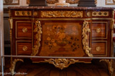 <center>Chambre sur cour.</center>Commode. Jean-Henri Riesener. 1774-1775. Commode à la façade en trois parties, masquant la division du meuble et des cinq tiroirs fermant à clefs. Un dessin à marqueterie à décor de vases de fleurs orne le panneau central trapézoïdal à montants incurvés à ressauts. Des bronzes dorés sont plaqués sur les pieds et sur chaque angle du meuble ainsi que sur la façade où il souligne la ceinture et le panneau central. Sur le pourtour en partie supérieure, une grande moulure avec une frise à jour en 5 parties. Dessus en plaque de marbre Sainte-Anne marron moucheté, d'origine du Languedoc ou Caunes minervois.