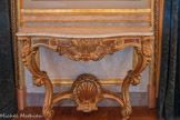 <center>Salon des Amiraux.</center>Dix consoles en bois doré, couvertes d’un plateau de marbre blanc. Les deux pieds en volutes sont réunis par une coquille avec tores de laurier. Les angles sont marqués par une coquille, le centre de la ceinture est orné d’un ressaut avec une ancre de marine. Jeanselme. 1825-1849.