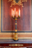 <center>Galerie des ports de guerre </center>Paire de candélabres à six branches en bronze patiné et doré. Ils reposent sur une base triangulaire ornée de trois bustes de sphinges reliées par une guirlande nouée. Leur fût est cannelé et terminé par une coupe d'où surgissent les six branches en forme de corne d'abondance. 1825-1849.