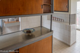<center>Immeuble Le Corbusier</center>La cuisine communique avec la salle à manger. Elle est équipée d’un mobilier intégré absolument pionnier pour l’époque : deux meubles de rangement structurent l’espace et offrent des plans de travail recouverts d’étain. Ces deux meubles conçuent par Charlotte Perriand servent à la fois de plan de travail et
de rangement pour la vaisselle et le linge. Placés
en équerre, ils sont composés d’une partie
basse posée au sol reliée par de minces tubes
d’acier à une partie haute. L’espace ainsi créé rend possible un système de passe-plat vers la salle à manger. Ces placards disposent de
parois coulissantes.