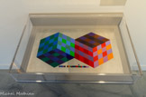 <center>Etude Méta 1970</center>Peinture glycérophtalique sur métal 50x31 cm
Collection particulière
Meta est une partition visuelle sur les figures impossibles. La contiguïté de deux cubes au niveau de la tranche engendre plusieurs lectures possibles fondées sur le Cube de Kepler. L’arrête paraît pleine ou vide en fonction des dispositions du cerveau. Le pattern à carreaux clairs et foncés, et de gamme bleue ou rouge, creuse de cavités optiques les surfaces du cube que le cerveau voudrait lire comme étant plates.